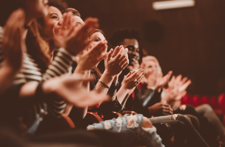 Photo of a crowd of people clapping for motivational speaker Roxanne Boudreaux, Lifestyle Clarity Coach